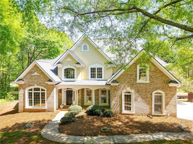 view of front facade featuring brick siding and stucco siding