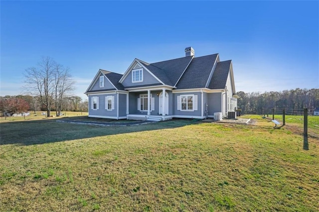 view of front of house featuring cooling unit, a chimney, a front yard, and fence