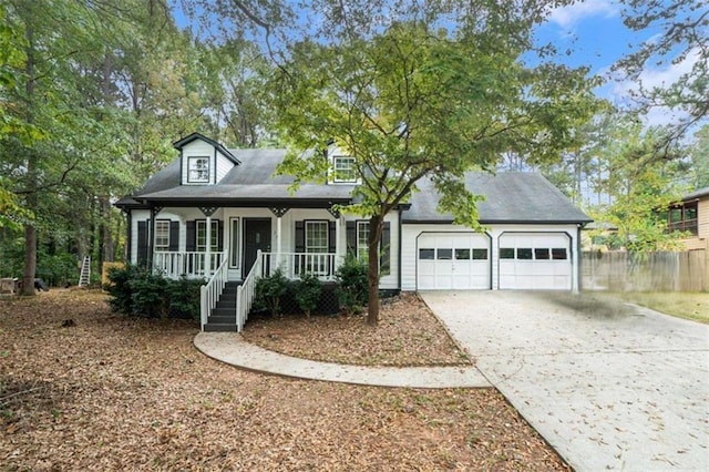 cape cod home featuring a garage, a porch, and concrete driveway