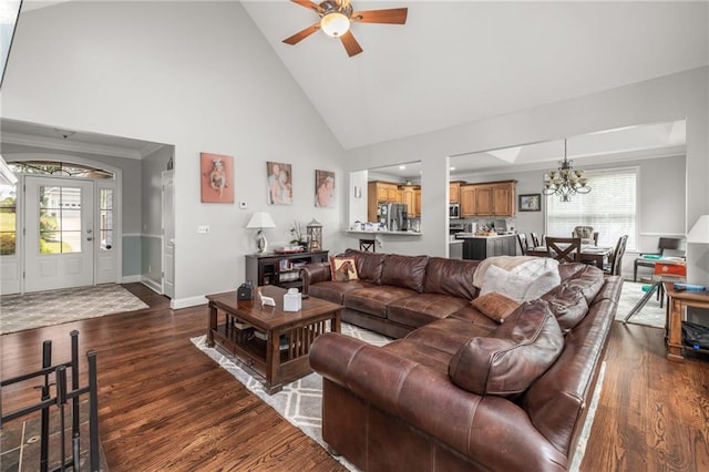 living room featuring crown molding, dark wood-type flooring, ceiling fan with notable chandelier, and high vaulted ceiling