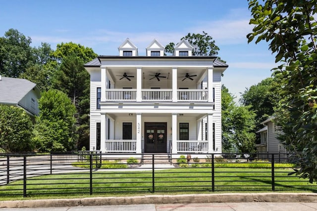 view of front of home featuring ceiling fan, a balcony, a front lawn, and covered porch