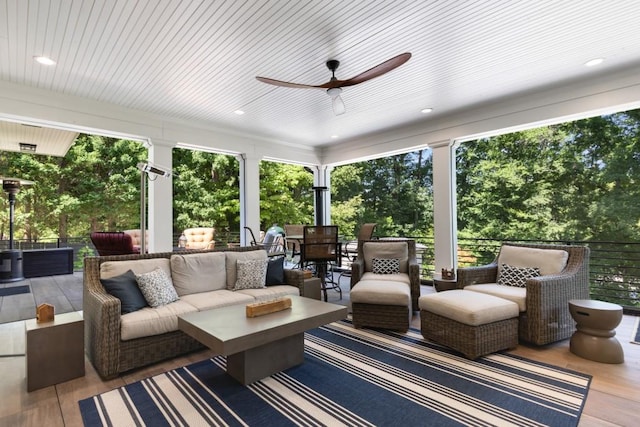 sunroom featuring wooden ceiling, ceiling fan, and a healthy amount of sunlight