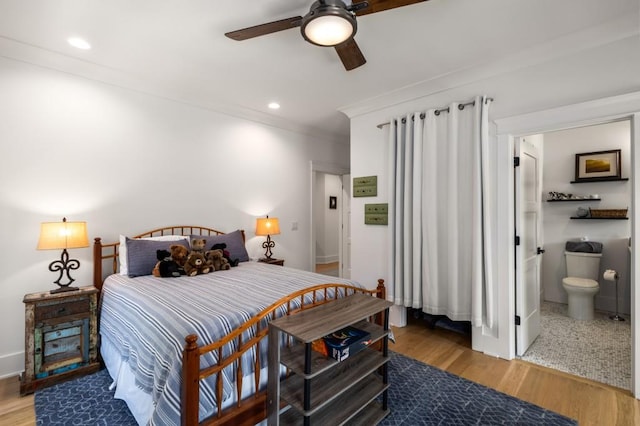 bedroom featuring hardwood / wood-style flooring, ceiling fan, ornamental molding, and ensuite bath