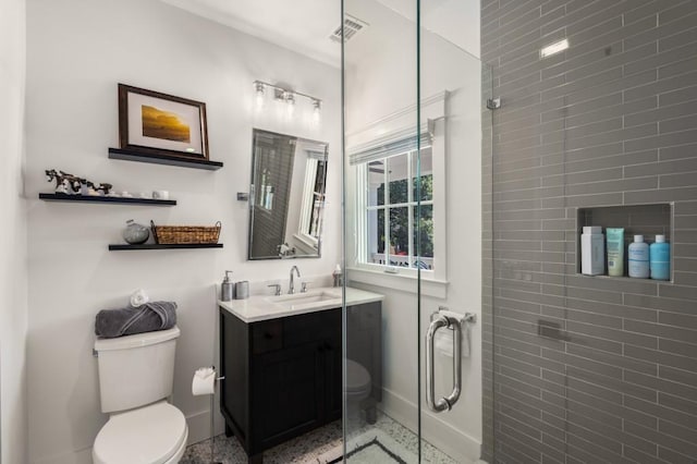 bathroom with vanity, a shower with shower door, and toilet