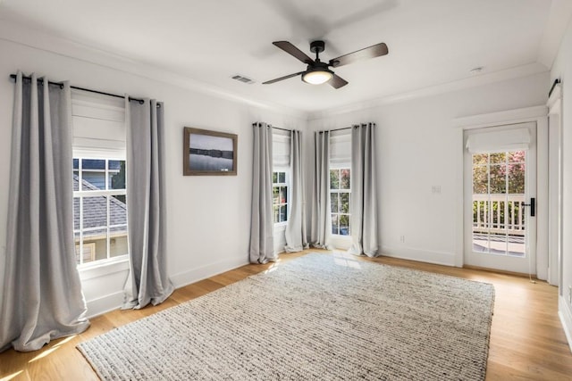 unfurnished room with ceiling fan, crown molding, a wealth of natural light, and light hardwood / wood-style flooring