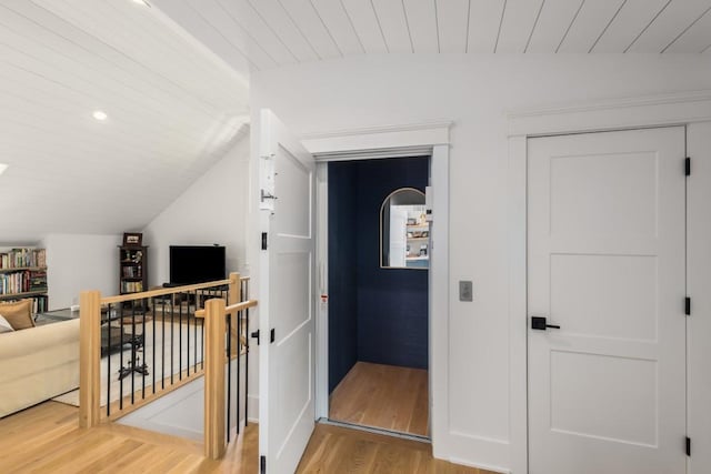 corridor with wood ceiling, light hardwood / wood-style floors, and lofted ceiling