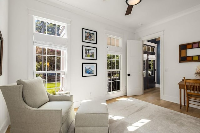 sitting room featuring ceiling fan, crown molding, and light hardwood / wood-style flooring