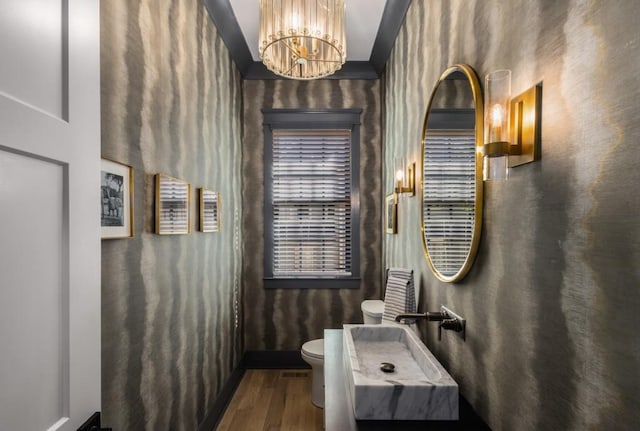 bathroom with sink, toilet, an inviting chandelier, and hardwood / wood-style flooring