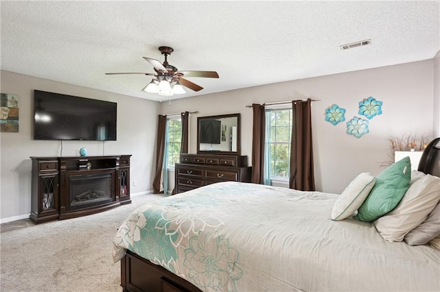 285 Aspen Way, Fayetteville, GA 30214 - carpeted bedroom featuring baseboards, a textured ceiling, a ceiling fan, and a glass covered fireplace
