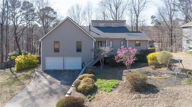 view of front facade featuring aphalt driveway, stairway, and a garage