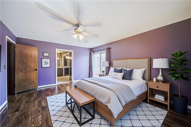 bedroom with a ceiling fan, ensuite bath, wood finished floors, and baseboards