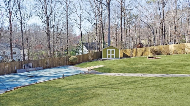 view of yard featuring an outdoor structure, a storage unit, and a fenced backyard