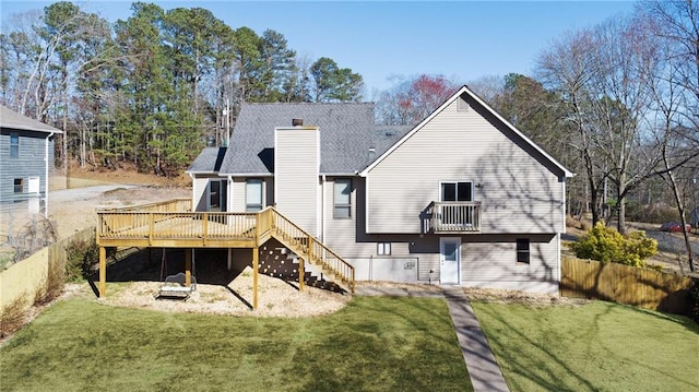 rear view of property with stairway, a lawn, a chimney, and fence