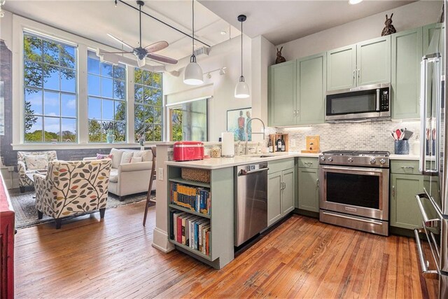 978 N Ave NE Unit 207, Atlanta, GA 30306 - kitchen with a peninsula, a sink, backsplash, light countertops, and appliances with stainless steel finishes