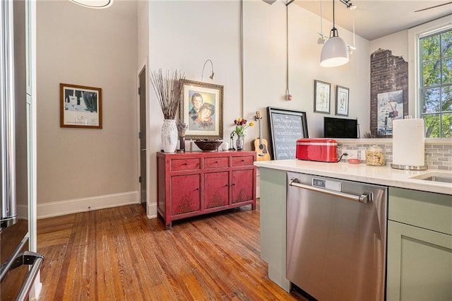978 N Ave NE Unit 207, Atlanta, GA 30306 - kitchen featuring pendant lighting, stainless steel dishwasher, hardwood / wood-style flooring, green cabinetry, and light countertops