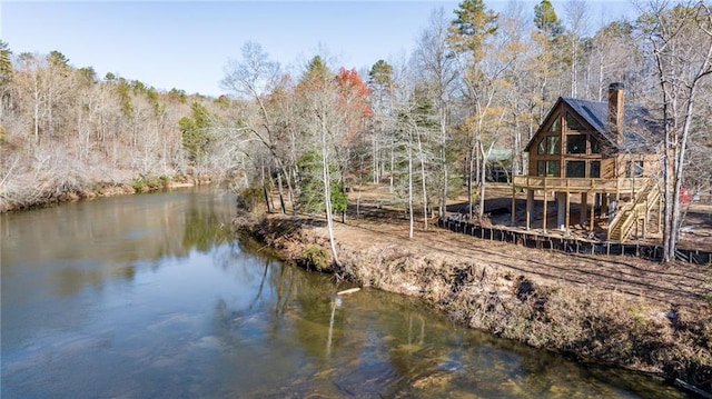 exterior space with a water view and a view of trees