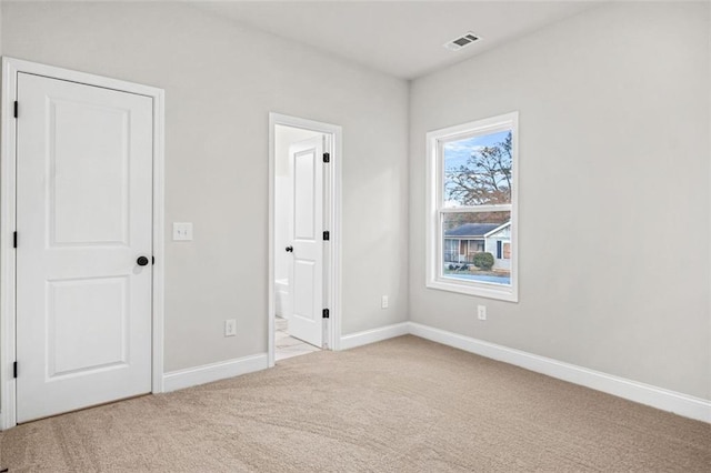 bedroom featuring lofted ceiling, light carpet, and connected bathroom