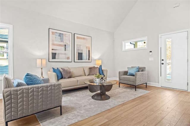 living room with light hardwood / wood-style flooring and high vaulted ceiling