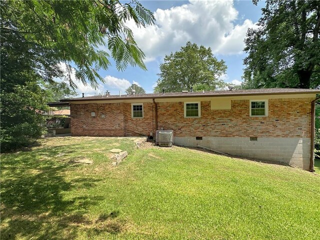 back of house featuring central AC and a lawn