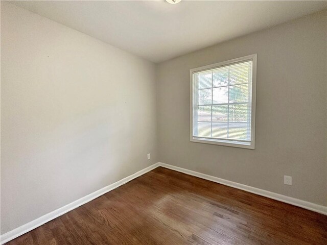 unfurnished room with dark hardwood / wood-style flooring