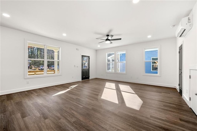 unfurnished living room with ceiling fan, an AC wall unit, and dark wood-type flooring