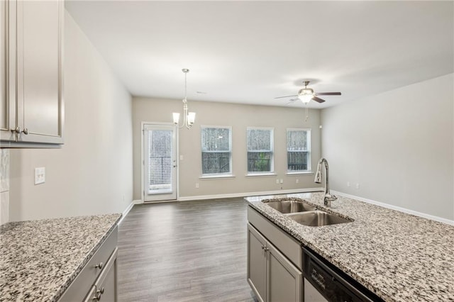 kitchen with pendant lighting, sink, gray cabinets, dark hardwood / wood-style floors, and light stone counters