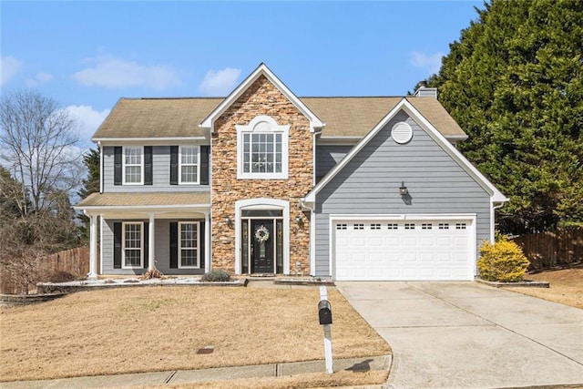 view of front of property with a garage, stone siding, fence, and concrete driveway