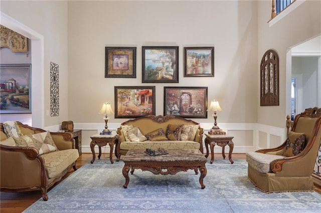 living area with dark wood-type flooring and a towering ceiling