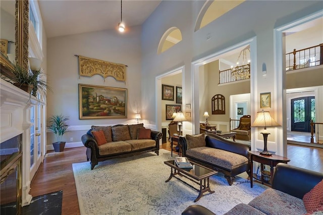 interior space featuring dark hardwood / wood-style flooring, an inviting chandelier, high vaulted ceiling, and french doors