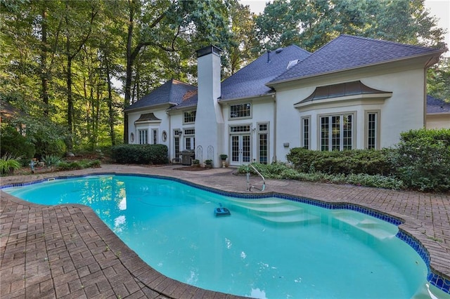 view of pool with french doors and a patio