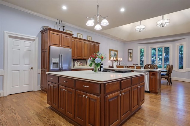 kitchen with a notable chandelier, light hardwood / wood-style floors, decorative light fixtures, and appliances with stainless steel finishes