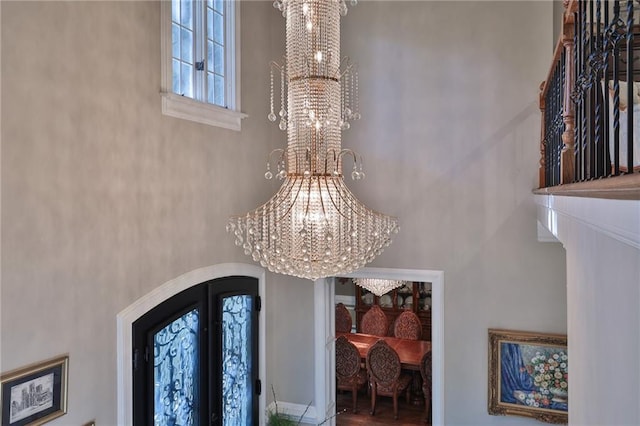 foyer entrance with a chandelier, a high ceiling, and wood-type flooring