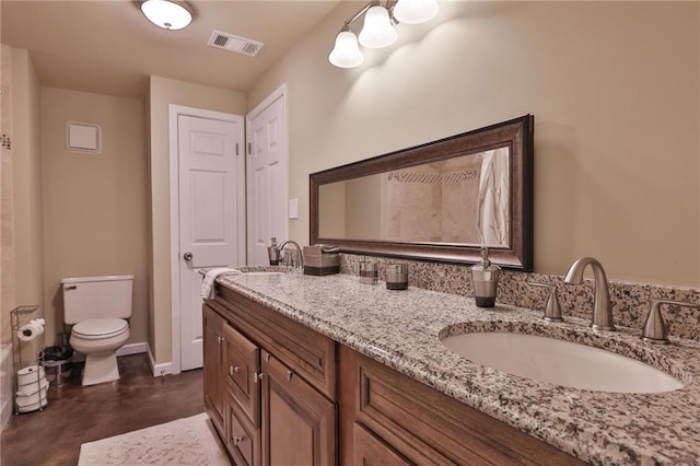 bathroom with toilet, double vanity, and tile flooring