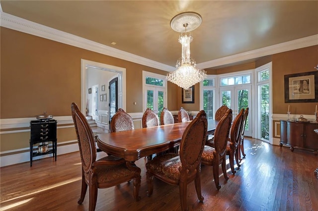 dining room with french doors, a chandelier, crown molding, and dark wood-type flooring