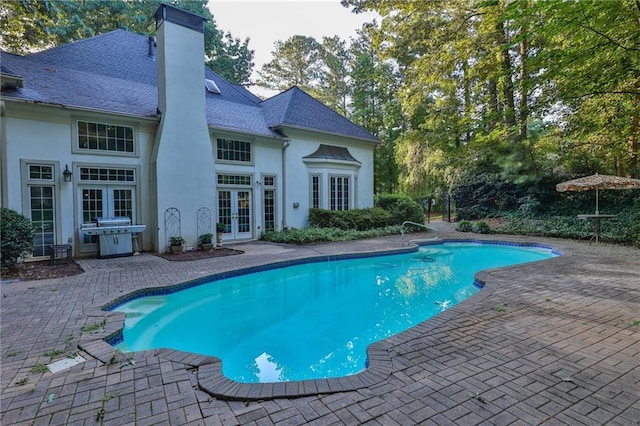 view of swimming pool with a patio area and french doors