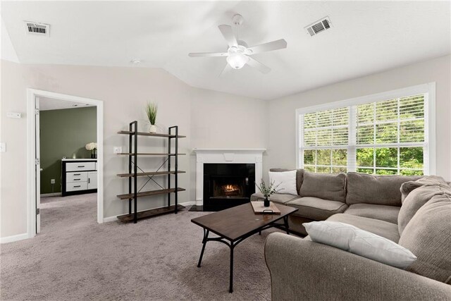 living area featuring ceiling fan, vaulted ceiling, carpet flooring, and visible vents