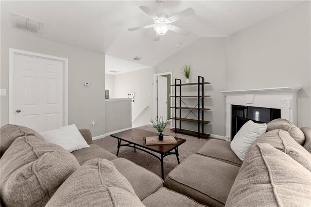 living area with carpet floors, baseboards, visible vents, and vaulted ceiling