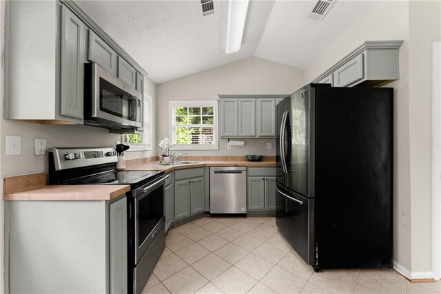 kitchen with visible vents, appliances with stainless steel finishes, lofted ceiling, and gray cabinetry