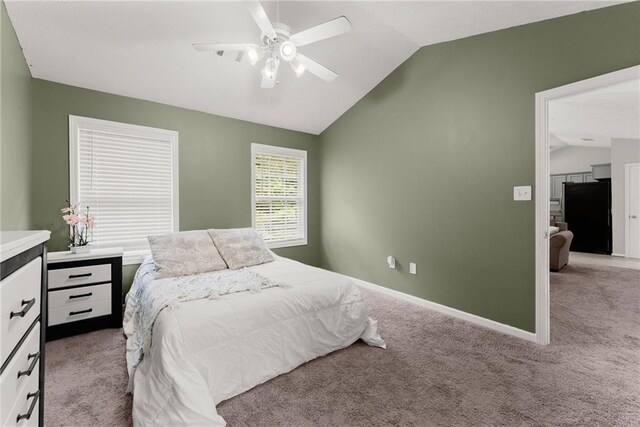 carpeted bedroom with ceiling fan, black fridge, baseboards, lofted ceiling, and visible vents