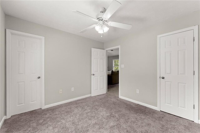 unfurnished bedroom featuring baseboards, a ceiling fan, and carpet flooring