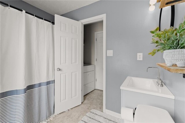 bathroom featuring washer / dryer and a shower with shower curtain