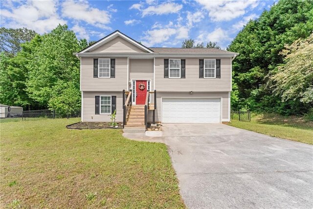 split foyer home with an attached garage, a front lawn, fence, and driveway