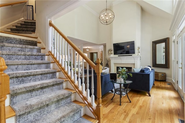 4404 Old Georgetown Trl, Atlanta, GA 30338 - staircase with wood finished floors, a towering ceiling, a fireplace, a chandelier, and baseboards