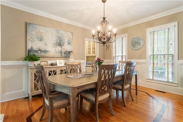 4404 Old Georgetown Trl, Atlanta, GA 30338 - dining area featuring a chandelier, wainscoting, wood finished floors, crown molding, and a decorative wall