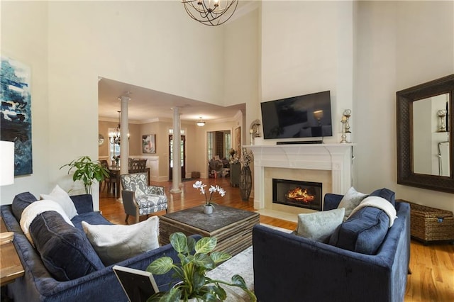 4404 Old Georgetown Trl, Atlanta, GA 30338 - living area featuring a chandelier, a towering ceiling, wood finished floors, ornamental molding, and a fireplace with flush hearth