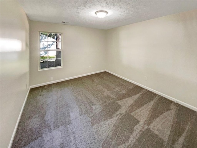 carpeted spare room featuring a textured ceiling