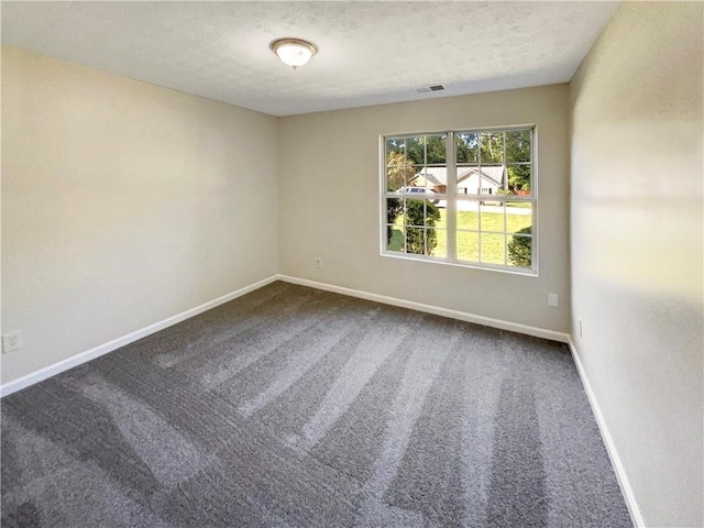 carpeted empty room with a textured ceiling