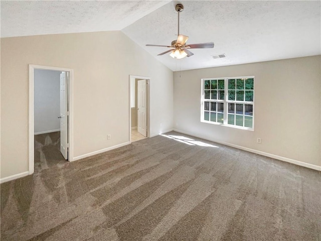 carpeted spare room featuring lofted ceiling, a textured ceiling, and ceiling fan