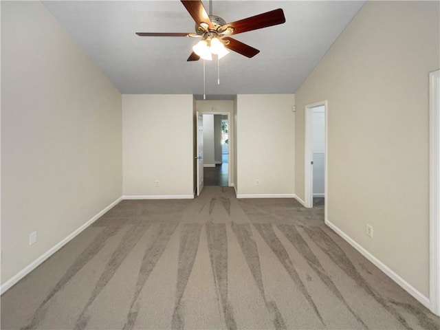 carpeted spare room with ceiling fan and vaulted ceiling