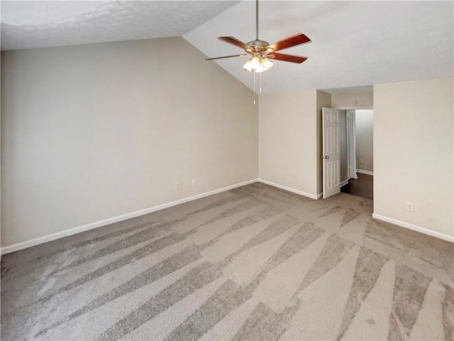 carpeted spare room with lofted ceiling and ceiling fan